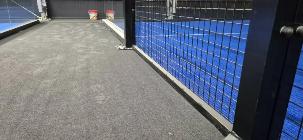 Poros, lábnyomos szőnyegburkolat a rácsos pályafal mellett takarítás előtt, BVSC Cupra Aréna
