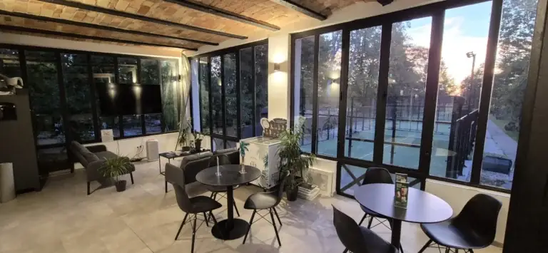 Tiszta, rendezett Padel Garden klubhelyiség panorámaablakokkal, kilátással a padelpályákra